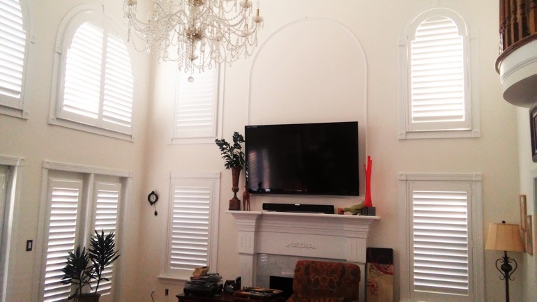 Southern California great room with wall-mounted television and arched windows.